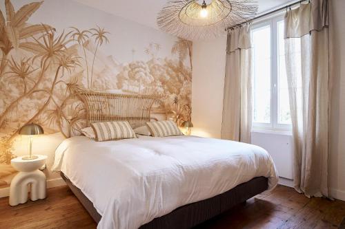 une chambre avec un grand lit et un lustre dans l'établissement Villa Condat, à Libourne