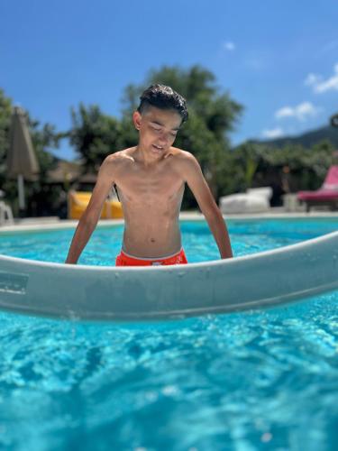 a young man in a kayak in a swimming pool at Natura Bungalows-Villa in Limenas