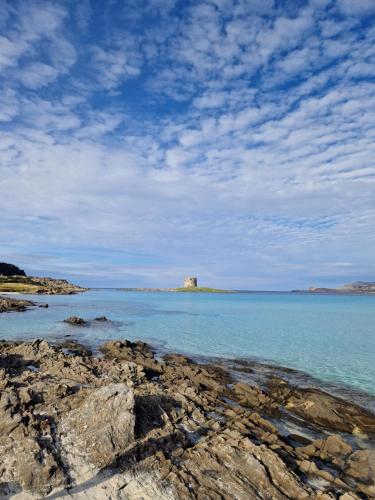 a view of the ocean with a lighthouse in the distance at Il Ronchetto in Sorso