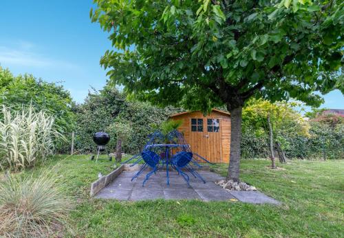 une table de pique-nique sous un arbre à côté d'un hangar dans l'établissement Le Troglogite Mignon - Maison et Jardin, à Amboise