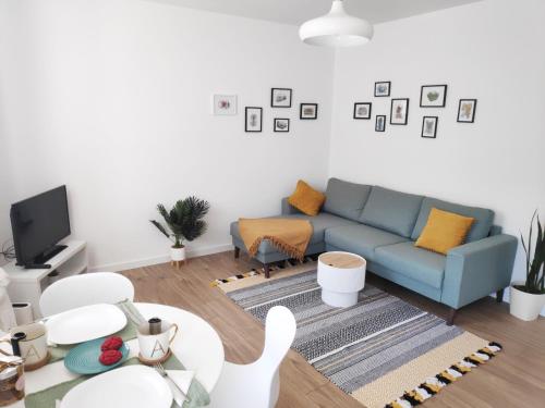 a living room with a blue couch and a tv at Te Amantia Apartment in Tirana