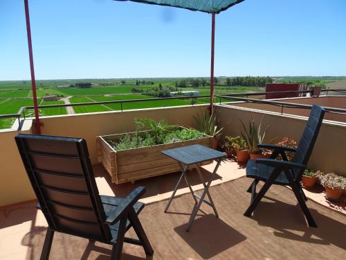 a patio with two chairs and a table on a balcony at Apartamento con vistas in Camarles