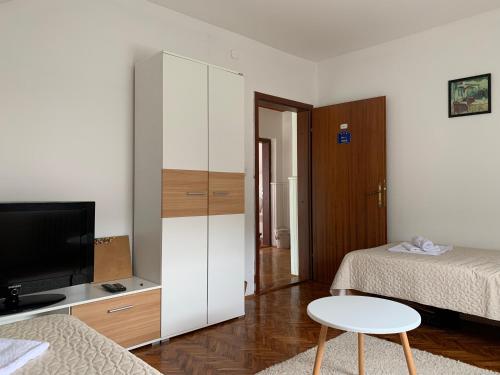 a room with a bedroom with a bed and a tv at Pansion "Dušica" in Bor