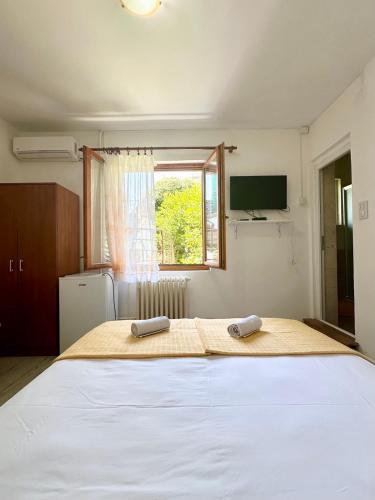 a bedroom with a large bed with two towels on it at Apartmani i sobe Radojičić in Bijela