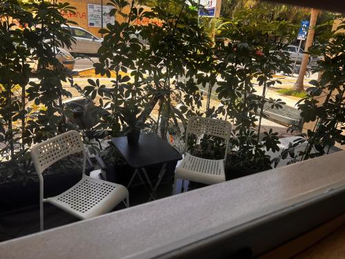 two chairs and a table with trees on a balcony at Modern apartment Downtown in Rethymno Town
