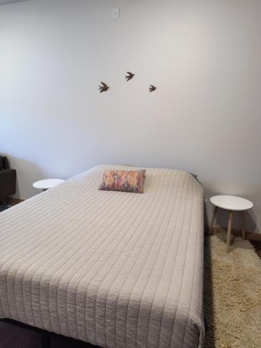 a bed in a room with two tables at Grewingk Suite - Homer Seaplane Base in Homer