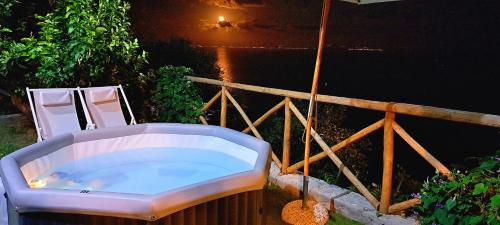 a bath tub sitting next to two chairs next to the water at Sea View Apartments Amalfi Coast by Amalfi Coast with Locals in Conca dei Marini