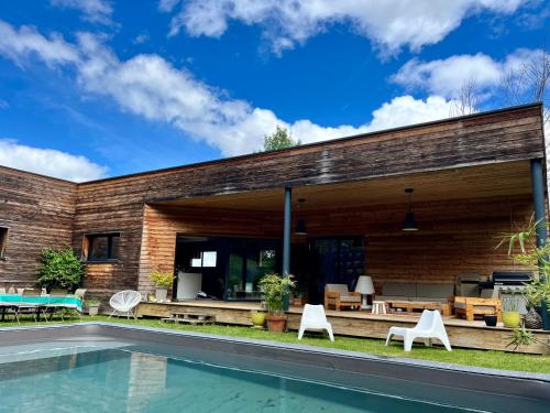 une maison en briques avec piscine et patio dans l'établissement Maison en bois au calme piscine, à Corbarieu