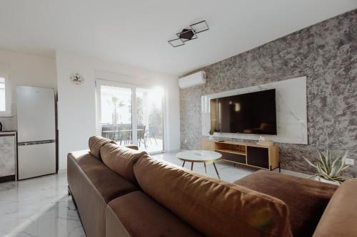 a living room with a couch and a tv at BRAND NEW! Villa Adriatic Bay2 with a private pool in Novalja