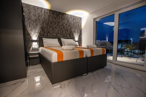 a bedroom with a bed and a large window at BRAND NEW! Villa Adriatic Bay2 with a private pool in Novalja