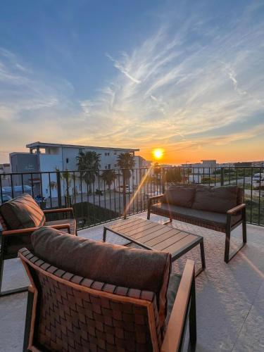 a balcony with couches and a table and the sunset at BRAND NEW! Villa Adriatic Bay2 with a private pool in Novalja