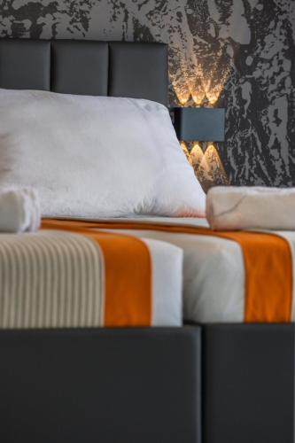 a bedroom with a bed with an orange and white blanket at BRAND NEW! Villa Adriatic Bay2 with a private pool in Novalja