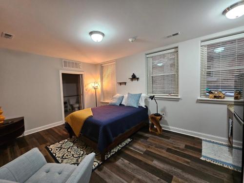 a bedroom with a bed and a couch and windows at Cute + Cozy Studio at The Inman - 207 in Champaign