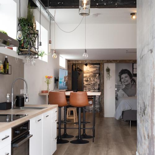 a kitchen with a table and chairs and a bedroom at Studio Met Verve, centrum met eigen parkeerplaats in Middelburg