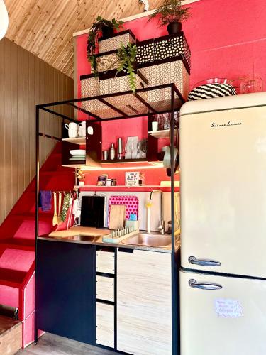 a toy kitchen with a refrigerator in a room at Amazing little house on an island with garden in Rīga