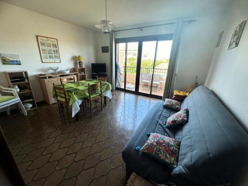 un salon avec un canapé bleu et une table dans l'établissement Résidence Espadon - Appartement à 100m de la plage avec 4 couchages MAE-1491, à Six-Fours-les-Plages