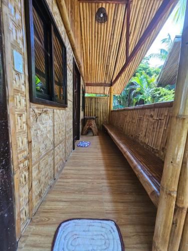a hallway of a house with wooden floors and windows at Big BamBoo Beach Resort Sipalay in Sipalay