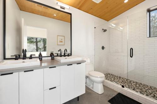 a white bathroom with two sinks and a shower at Tanglewood Cabin-Lake Access-Private-Modern in Rambo Riviera