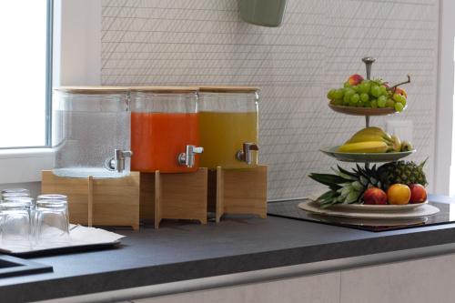 a kitchen counter with two containers of juice and fruit at Lu Mari Rooms in Marina di Ragusa