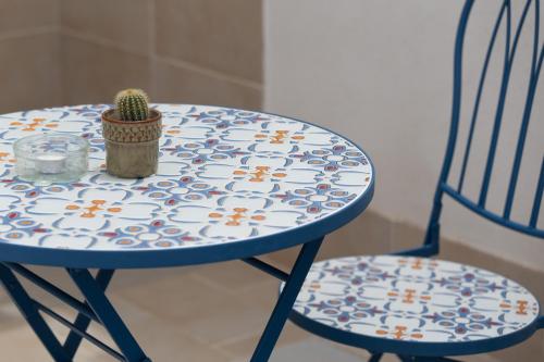 a blue table with a cactus on it next to two chairs at Lu Mari Rooms in Marina di Ragusa