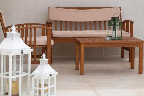 a room with a bench and a table and chairs at Lu Mari Rooms in Marina di Ragusa