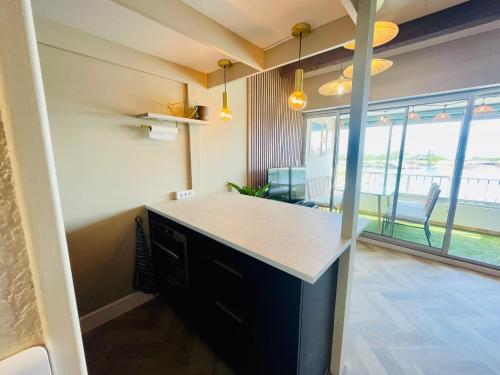 une cuisine avec un comptoir et une grande fenêtre dans l'établissement Cap d'Agde T2 4-6 personnes Mezzanine Vue mer Piscine Wifi, au Cap d'Agde