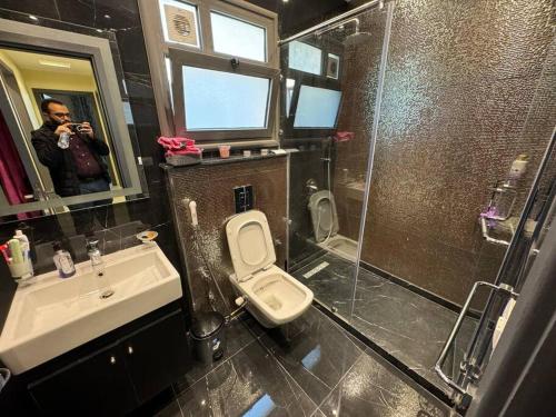 Ein Mann fotografiert ein Badezimmer in der Unterkunft Charming Luxury Apartment - New Cairo in Kairo