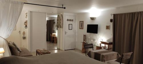 a living room with a bed and a room with a television at La Casanat in Montgiscard