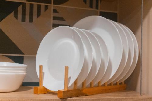 a stack of white plates on a shelf at Alojamiento disponible para la Comic Con Colombia NID104 By Roots Rentals in Medellín