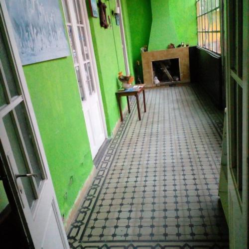 an empty room with green walls and a floor with a table at Casa Ituzaingó in Minas