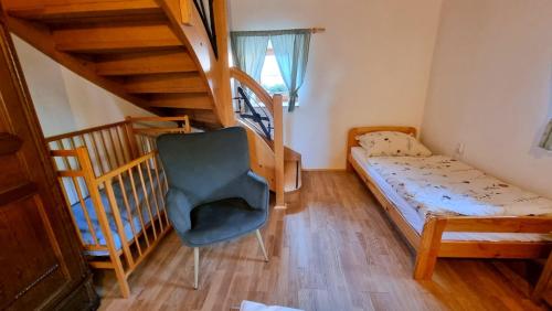 a small bedroom with a bed and a staircase at Chalupa Pod Zámečkem, Myslkovice in Myslkovice