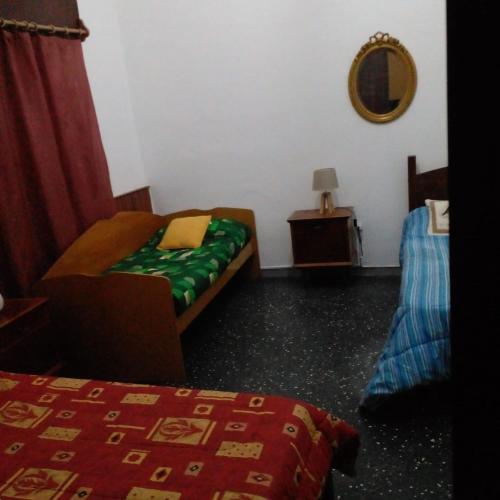 a room with a bed and a chair and a mirror at Casa Ituzaingó in Minas