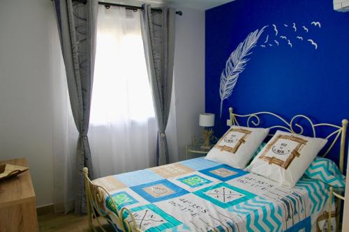 a bedroom with a bed with a blue wall at Détente et évasion entre Hossegor et Biarritz in Tarnos