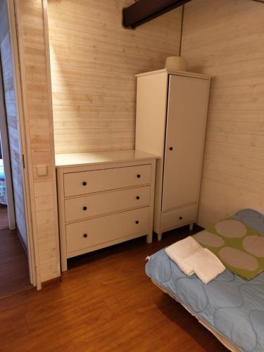 a bedroom with a bed and a dresser and a cabinet at Dorė in Nida