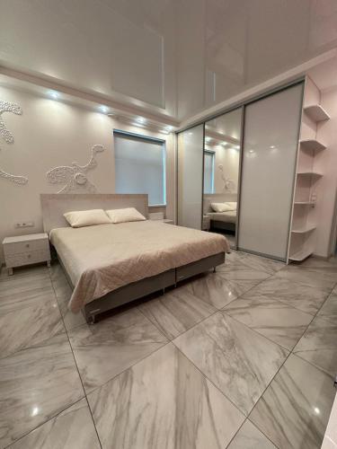 a bedroom with a bed and a large marble floor at Kairos apartment in Ventspils