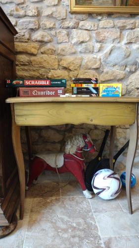 a wooden table with a pile of books and a dog under it at Residence de la demi-lune in Entrains-sur-Nohain