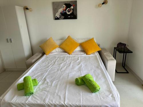 カンヌにあるSuper Apartment, Parking, Terrace, Lift, WIFI, Palm Beach, Cannesの白い大型ベッド(黄色と緑の枕付)