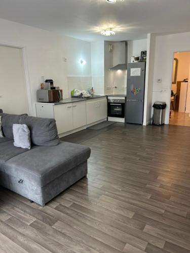 un salon avec un canapé et une cuisine dans l'établissement Superbe appartement, à Aubervilliers