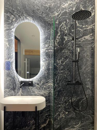 un bagno con lavandino e specchio di Appartement moderne dominant la ville a Pontarlier