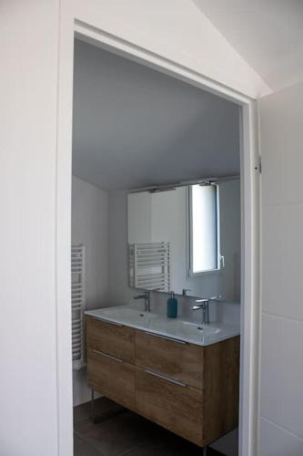 une salle de bain avec un lavabo et un miroir dans l'établissement Le Cottage Des Glycines - Piscine chauffée, à Moliets-et-Maa