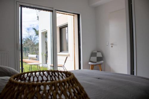 une chambre avec un lit et une grande fenêtre en verre dans l'établissement Le Cottage Des Glycines - Piscine chauffée, à Moliets-et-Maa
