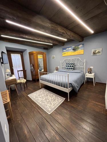 a bedroom with a bed in a room with wooden floors at L Arcolaio in San Maurizio dʼOpaglio