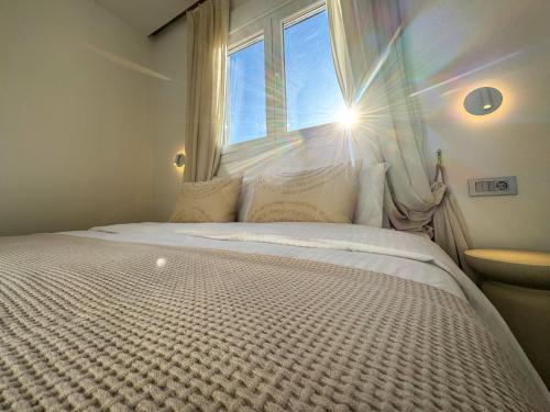 a bedroom with a large bed with a window at Cerro Fine Living in Ermoupoli