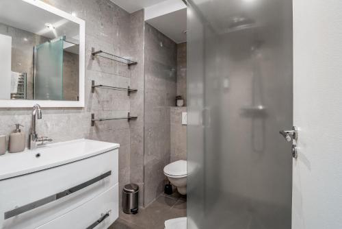 a bathroom with a white sink and a toilet at Apartments Du Louvre St Honoré in Paris
