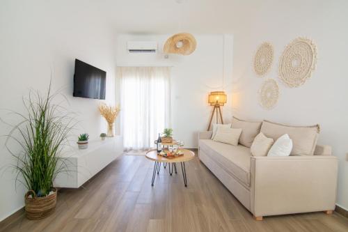 a white living room with a white couch and a table at Cerro Fine Living in Ermoupoli