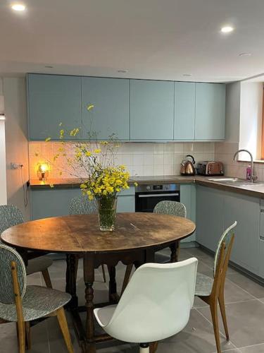 une cuisine avec une table avec un vase de fleurs dessus dans l'établissement La Pomme de Pin, à Le Biot