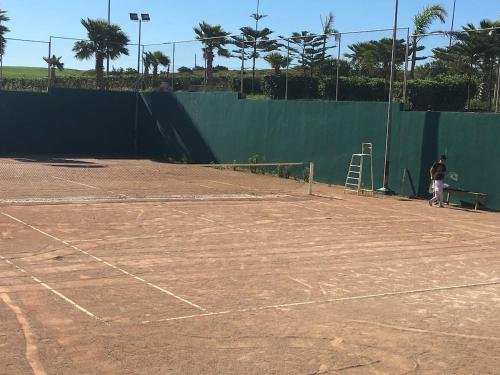 a man is standing on a tennis court at vacance de prestige à ASILAH MARINA GOLF in Asilah