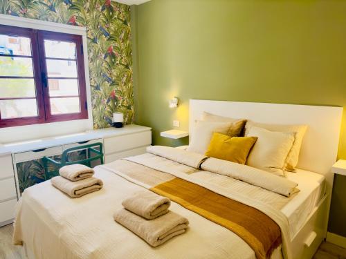 um quarto com uma cama grande com toalhas em Tranquil Hillside with Oceanview and Pool em Los Cristianos