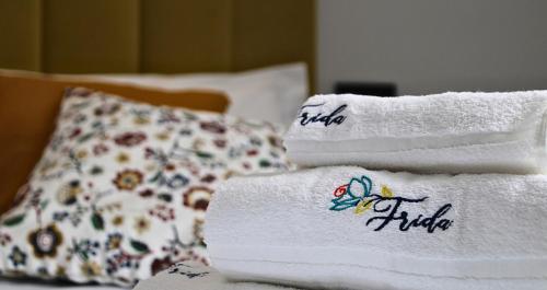 a stack of towels on a bed with a pillow at Frida Luxury B&B in Vietri sul Mare
