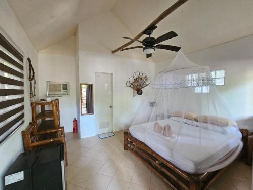 a bedroom with a bed and a ceiling fan at Big BamBoo Beach Resort Sipalay in Sipalay